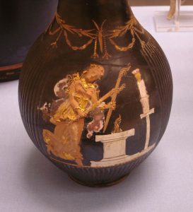 Hecate holding two torches and dancing in front of an altar